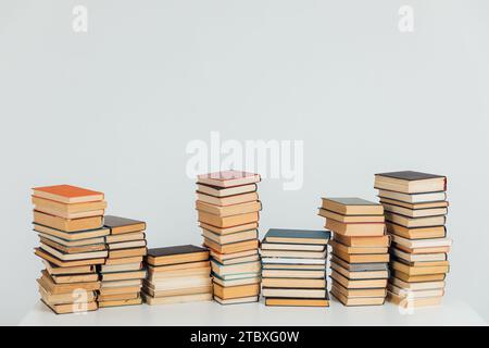 Stapel alter Bücher in der Studierendenbibliothek auf weißem Hintergrund Stockfoto