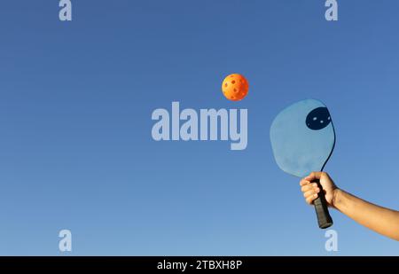 Pickleball-Spieler, der mitten im Spiel den Ball schlägt Stockfoto