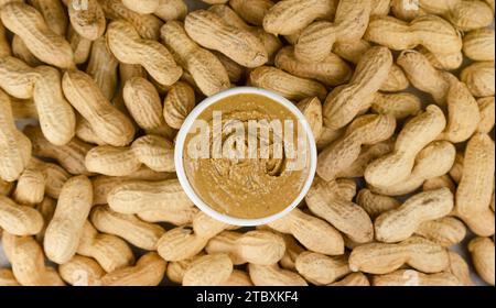 Erdnussbutter auf dem Hintergrund von Erdnüssen, Draufsicht Stockfoto