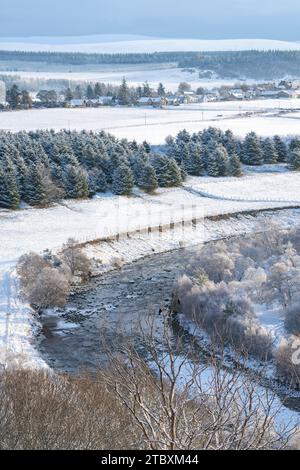 Fluss Avon mit dem Dorf Tomintoul in der Ferne im Schnee. Cairngorms, Highlands, Schottland Stockfoto