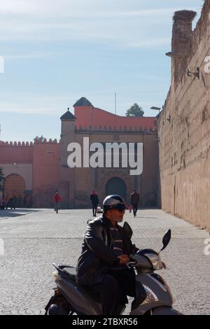 Mauern des Badi-Palastes, von der Straße aus gesehen, wenn ein Radfahrer in Marrakesch, auch bekannt als Marrakesch, vorbeifährt, 9. Dezember 2023 Stockfoto