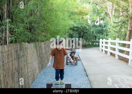 Kleiner asiatischer Junge, der draußen Kindersportgeräte spielt Stockfoto