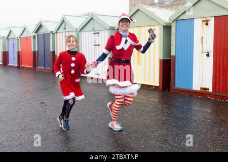 Hove Seafront, City of Brighton & Hove, East Sussex, Großbritannien. Über 600 Teilnehmer kommen zum jährlichen Santa Dash. Ein 5 km langer Spendenlauf für Wohltätigkeitsorganisationen, bei dem Spenden für die Kinderkaritative Brighton & Hove Rocking Horse Appeal an der Küste von Hove gesammelt werden. Die Wohltätigkeitsorganisation unterstützt Babys, Kinder und Jugendliche sowie ihre Familien im Royal Alexandra Children’s Hospital und der Trevor Mann Baby Unit in Brighton am 9. Dezember 2023. David Smith/Alamy Live News Stockfoto