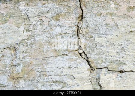 Großer vertikaler Riss mit langer Kurve an alter Putz- und lackierter Wand. Kopierbereich. Selektiver Fokus. Stockfoto