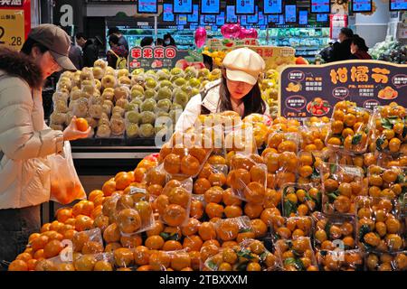 YANTAI, CHINA - 9. DEZEMBER 2023 - Verbraucher kaufen Obst in einem Supermarkt in Yantai, ostchinesischer Provinz Shandong, 9. Dezember 2023. Stockfoto