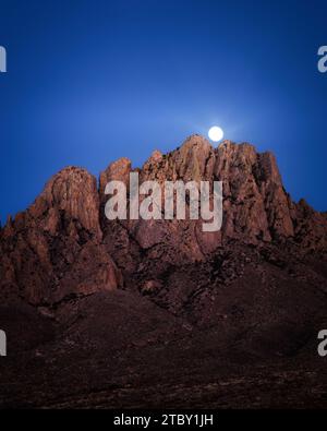 Der Mond erhebt sich hinter den Organ Mountains in der Nähe von Las Cruses, New Mexico. Stockfoto