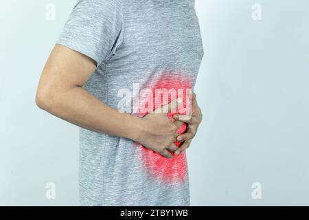 Mann mit starken Magenschmerzen. Hand eines Reifen Mannes mit Bauch, der an Schmerzen, Durchfall oder Verdauungsproblemen leidet. Stockfoto