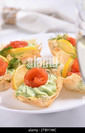 Avocado mit Frischkäse in das zarteste Mousse, eine Scheibe Lachs und Zitrone geschlagen. Serviert in knusprigen Körben mit eingebackenem Phyllo-Teig Stockfoto