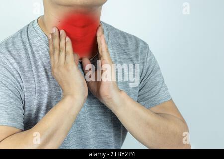 Asiatischer Mann, der den Hals mit der Hand berührt, weil er an Halsschmerzen leidet Stockfoto