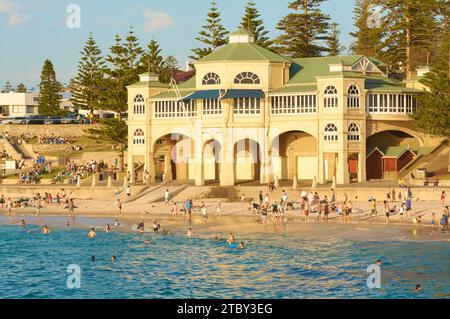 Viele Leute schwimmen und genießen Cottesloe Beach vor dem Indiana Teahouse Gebäude an einem heißen späten Frühlingstag in Perth, Western Australia. Stockfoto