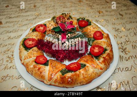 Köstlicher herzhafter Kuchen mit Spinat, Schinken und Tomaten als Weihnachtskranz Stockfoto