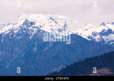 Ein Blick auf zerklüftete Berge mit Schnee von der Straße zwischen Gangtey und Punakha im Himalaya-Königreich Bhutan. Stockfoto