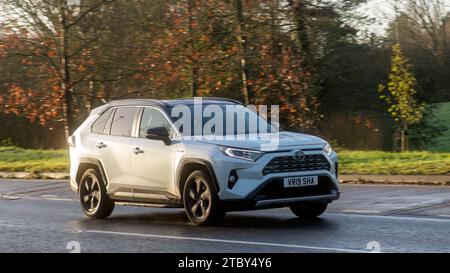 Milton Keynes, Bucks, UK - 8. Dezember 2023: 2019 weißer Hybrid-Elektrofahrzeug Toyota RAV4 SUV fahren auf nasser Straße Stockfoto