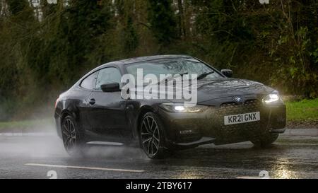 Milton Keynes, Bucks, UK - 9. Dezember 2023: 2021 BMW 420D M Sport Elektrodieselauto fährt auf nasser Straße, im Regen und bei eingeschalteten Scheinwerfern Stockfoto