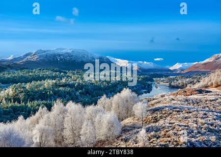 Glen Affric Cannich Schottland Wintersonne am Morgen über dem Loch, den Caledonian Pines und weit entfernten schneebedeckten Hügeln Stockfoto