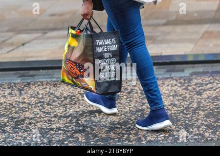 Tesco Flaschenbeutel aus recyceltem Kunststoff in Preston, Großbritannien. Dezember 2023. Weihnachtsläden, Shopper, Einkaufen an einem nassen Tag in der Fishergate High Street. Kredit ; MediaWorldImages/AlamyLiveNews Stockfoto