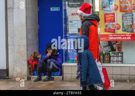 Bettler mit Hund in Preston, Großbritannien. Dezember 2023. Schlafender Rough zu Weihnachten. Geschäfte, Shopper, Einkaufen an einem nassen Tag in der Fishergate High Street. Stockfoto