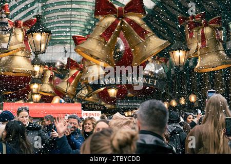 Leute, die den falschen Schneefall in London genießen, Covent Garden Stockfoto