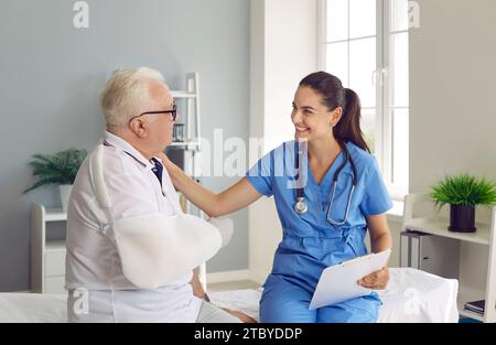 Schöne junge Ärztin tröstet ungesunden älteren Mann bei der Konsultation. Stockfoto