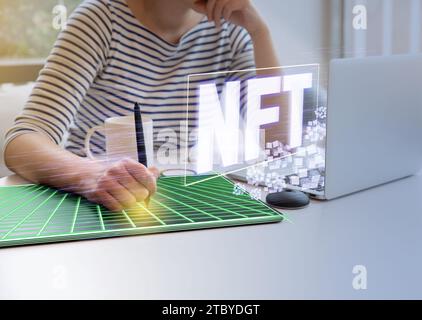 Frau mit Tablet und Laptop zur Veröffentlichung von NFT-Grafiken (Hologramm) Stockfoto