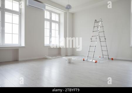 Leeres, unmöbliertes Zimmer mit Leiter und Farbeimer Stockfoto