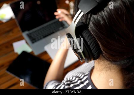Nahaufnahme einer Frau, die ein Headset trägt und eine Online-Vorlesung anhört Stockfoto