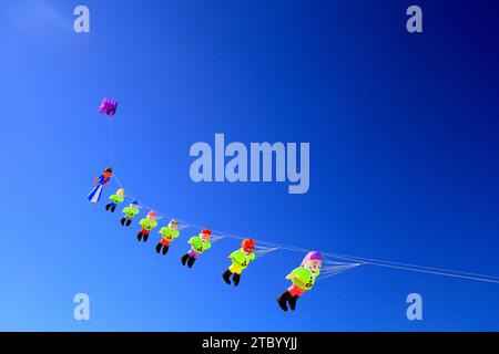 Schneewittchen und die sieben Zwerge fliegen über den Strand La Concha, Fuerteventura, die Kanarischen Inseln, Spanien. Vom November 2023. cym Stockfoto