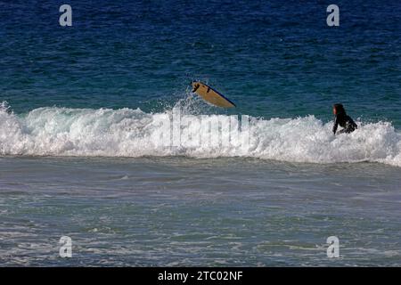 Der Surfer verschwindet unter einer Welle, während das Sur-Board abhebt. Surfen am Piedra Beach, El Cotillo, Fuerteventura, den Kanarischen Inseln, Spanien. Vom November 2023 Stockfoto