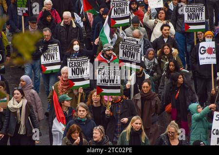 London, Großbritannien. Dezember 2023. Die Demonstranten halten während der Demonstration an der Victoria Embankment Plakate mit dem Titel „Ceasefire Now“. Tausende von Menschen marschierten solidarisch mit Palästina in Zentral-London und forderten einen Waffenstillstand während des Krieges zwischen Israel und der Hamas. Quelle: SOPA Images Limited/Alamy Live News Stockfoto