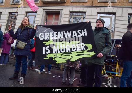 London, Großbritannien. Dezember 2023. Die Demonstranten halten während der Demonstration ein Banner mit der aufschrift „Greenwash is Mord“. Klimaaktivisten versammelten sich vor dem Hauptquartier von BP in Zentral-London, um gegen die Übernahme der COP28 durch Ölkonzerne zu protestieren und für Klimagerechtigkeit zu plädieren. (Foto: Vuk Valcic/SOPA Images/SIPA USA) Credit: SIPA USA/Alamy Live News Stockfoto