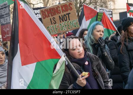 London, Großbritannien. Dezember 2023. "Kinder zu bombardieren ist keine Selbstverteidigung." Hunderttausende marschieren in London, um einen vollständigen Waffenstillstand in Gaza zu fordern, wo israelische Truppen über 17.000 Menschen getötet haben, darunter mehr als 7.000 Kinder. Bombenanschläge haben humanitäre Hilfe und medizinische Behandlung unmöglich gemacht, und weit verbreitete Todesfälle durch Krankheiten und Hunger scheinen jetzt unvermeidlich zu sein. Die Demonstranten fordern ein Ende des Völkermords und eine politische Lösung, um Palästina Frieden und Gerechtigkeit nach dem Völkerrecht zu bringen. Peter Marshall/Alamy Live News Stockfoto