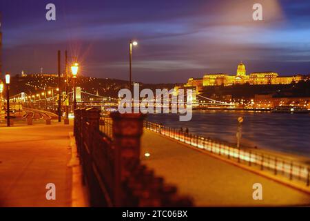 Budapest, Ungarn - 4. Dezember 2023: Königspalast oder das Budaer Schloss und die berühmte Kettenbrücke nach Sonnenuntergang mit Lichtern in der donau Stockfoto