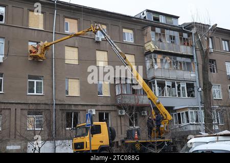 Nicht exklusiv: CHARKIW, UKRAINE - 8. DEZEMBER 2023 - Arbeiter verwenden eine Hubarbeitsbühne, um Spanplatten zu installieren, um die Fenster zu ersetzen, die b Stockfoto