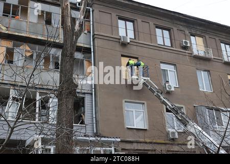 Nicht exklusiv: CHARKIW, UKRAINE - 8. DEZEMBER 2023 - Arbeiter verwenden eine Hubarbeitsbühne, um Spanplatten zu installieren, um die Fenster zu ersetzen, die b Stockfoto