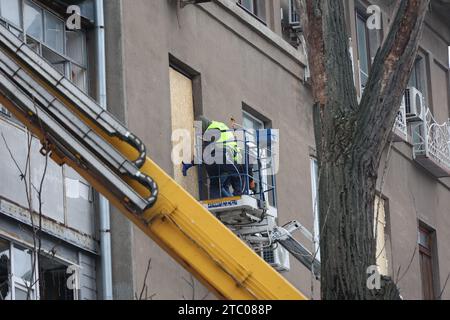 Nicht exklusiv: CHARKIW, UKRAINE - 8. DEZEMBER 2023 - Arbeiter verwenden eine Hubarbeitsbühne, um Spanplatten zu installieren, um die Fenster zu ersetzen, die b Stockfoto