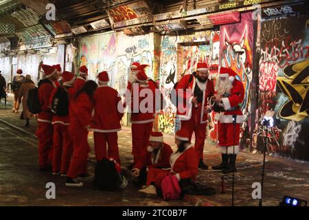 London, Großbritannien. 09/Dezember/2023 Menschenmassen von Santas ziehen in die Straßen von London. Bei der jährlichen Santacon-Veranstaltung werden massenhaft Menschen als Weihnachtsmann gekleidet und eine Route durch London folgen, um Kindern Geschenke zu schenken. Die Santas treffen sich am beliebten Graffiti-Ort Leake Street in der Nähe der Waterloo Station, bevor es in die Stadt geht. Vermerk: Roland Ravenhill/Alamy. Stockfoto