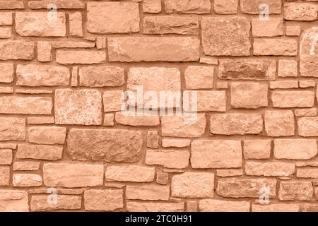 Farbe des Jahres 2024: Pfirsichfuzz. Einfache Steinwand. Stockfoto