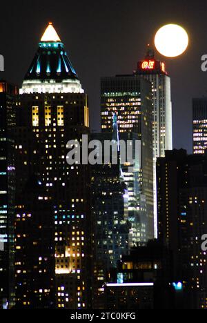 Der Vollmond erhebt sich über den Wolkenkratzern von Manhattan Stockfoto