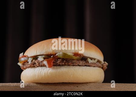 Perfekter leckerer Hamburger auf Holztisch auf braunem Hintergrund Stockfoto