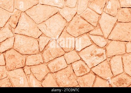 Alte Grunge Stein Wand Hintergrund, Textur. Die Farbe des Jahres 2024 Peach Fuzz. Stockfoto