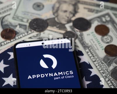 Deutschland. Dezember 2023. In dieser Fotoabbildung wird ein AppDynamics-Teil des Cisco-Logos auf einem Smartphone mit US-Dollar-Banknoten und -Münzen im Hintergrund angezeigt. (Credit Image: © Igor Golovniov/SOPA images via ZUMA Press Wire) NUR REDAKTIONELLE VERWENDUNG! Nicht für kommerzielle ZWECKE! Stockfoto