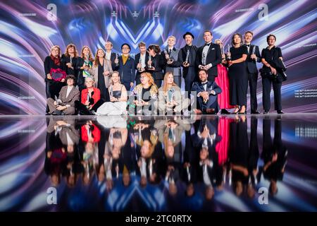 Berlin, Deutschland. Dezember 2023. Am Ende der Zeremonie treffen sich die Gewinner des Europäischen Filmpreises für ein Gruppenfoto auf der Bühne. Die European Film Academy (EFA) überreicht die Preise bei einer Gala in der Arena Berlin. Quelle: Christoph Soeder/dpa/Alamy Live News Stockfoto