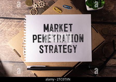 Geschäfts- und Finanzkonzept. Auf dem Tisch befindet sich ein Notizbuch, ein Stift und eine Visitenkarte mit der Aufschrift - MARKTDURCHDRINGUNG. Stockfoto