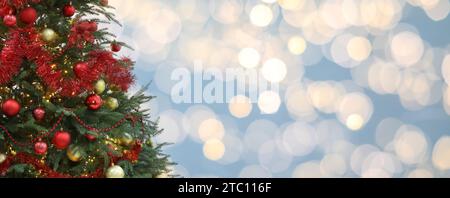 Weihnachtsbaum mit roten und goldenen Weihnachtskugeln vor verschwommenem Hintergrund, Bokeh-Effekt. Bannerdesign mit Platz für Text Stockfoto