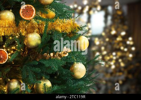 Weihnachtsbaum mit goldenen Weihnachtskugeln vor verschwommenem Hintergrund, Bokeh-Effekt. Leerzeichen für Text Stockfoto