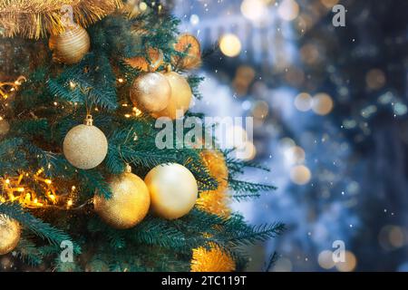 Weihnachtsbaum mit goldenen Weihnachtskugeln vor verschwommenem Hintergrund, Bokeh-Effekt. Leerzeichen für Text Stockfoto