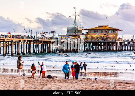 Touristen machen Fotos am Santa Monica Beach, mit Santa Monica Pier im Hintergrund, Sommernachmittag in Südkalifornien Stockfoto
