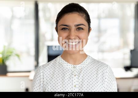 Kopffoto-Porträt einer lächelnden indischen Mitarbeiterin, die posiert Stockfoto