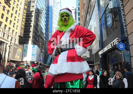 New York, Usa. Dezember 2023. Ein SantaCon-Teilnehmer in einem Grinch-Kostüm steht auf der Straße. In Manhattan, New York City, versammelten sich Schwärmer, die als Weihnachtsmann verkleidet waren, zur SantaCon, einem jährlichen Weihnachtsbummel, der Geld für wohltätige Zwecke sammelte. Die Spender erhielten Zutritt zu teilnehmenden Veranstaltungsorten wie Bars und Clubs. Quelle: SOPA Images Limited/Alamy Live News Stockfoto