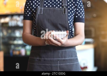 Ein Frauenkaffee auf dem Vorfeld hält ein Memo bereit, um Ordnung anzunehmen. Stockfoto